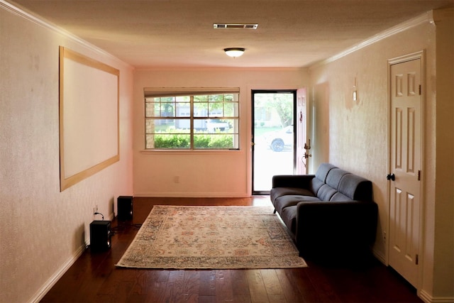 living area with dark wood-type flooring, visible vents, crown molding, and baseboards