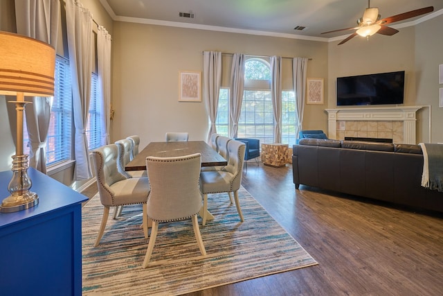 dining room with dark wood-style flooring, a ceiling fan, visible vents, and ornamental molding