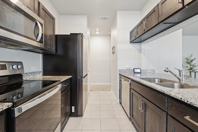 4538 Cherbourg St, Dallas, TX 75216 - kitchen with stainless steel appliances, a sink, dark brown cabinets, and baseboards