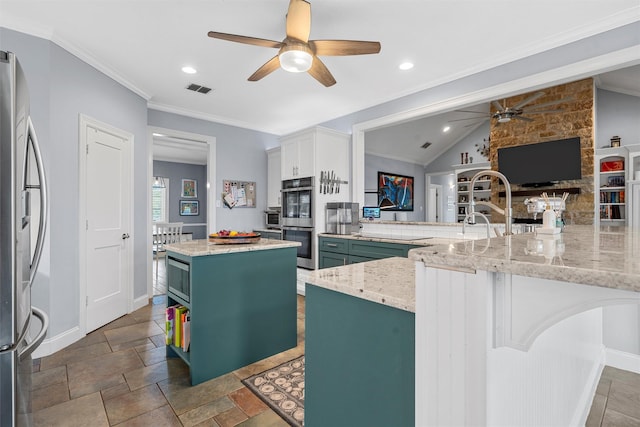 kitchen with visible vents, a ceiling fan, a center island, baseboards, and appliances with stainless steel finishes