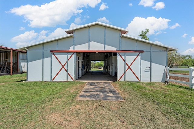 back of property featuring fence, an outbuilding, and a yard