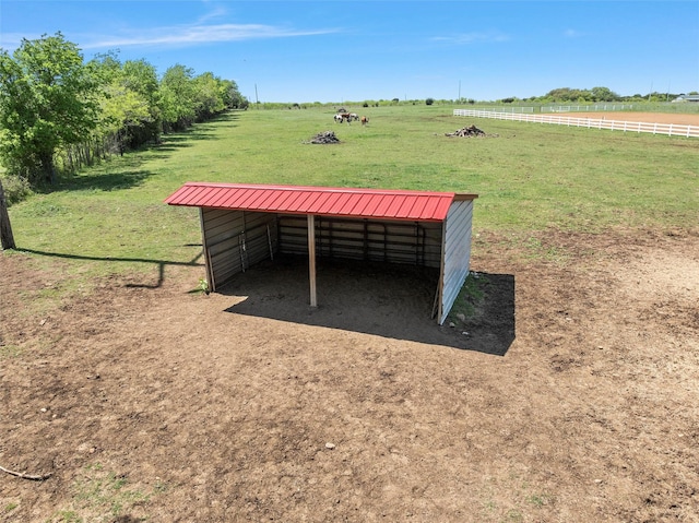 view of home's community with a rural view, an exterior structure, and an outbuilding