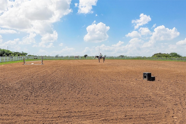 view of community featuring an enclosed area, fence, and a rural view