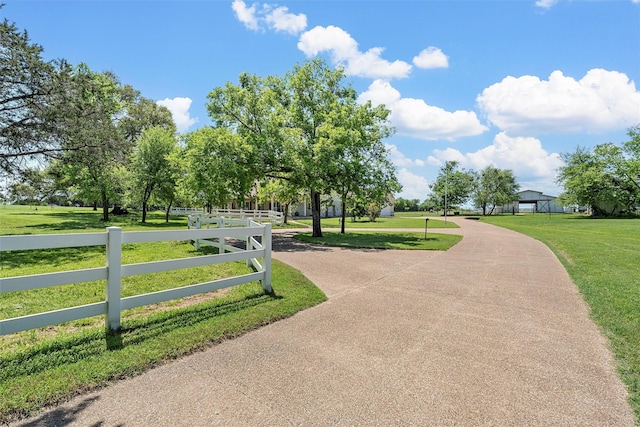 view of community featuring a lawn and fence