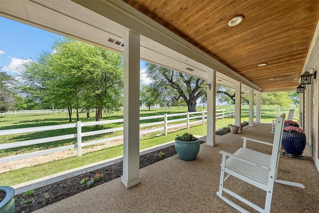 view of patio featuring a porch and fence