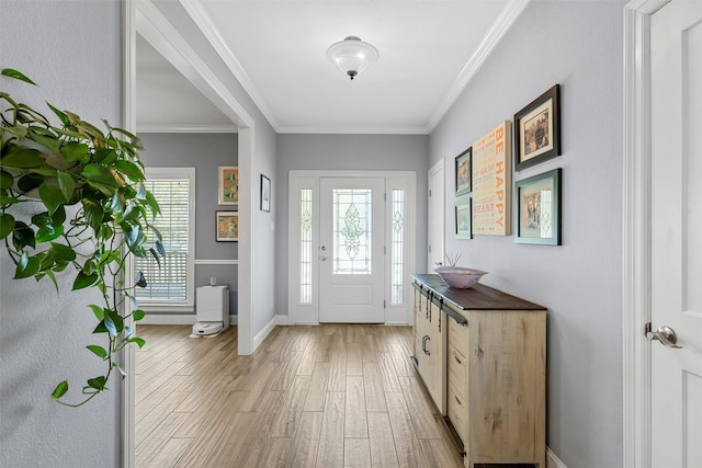foyer entrance with light wood-style floors, baseboards, and ornamental molding