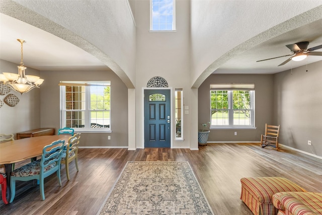 3101 Clear Springs Dr, Forney, TX 75126 - foyer entrance featuring ceiling fan with notable chandelier, arched walkways, a textured ceiling, wood finished floors, and baseboards