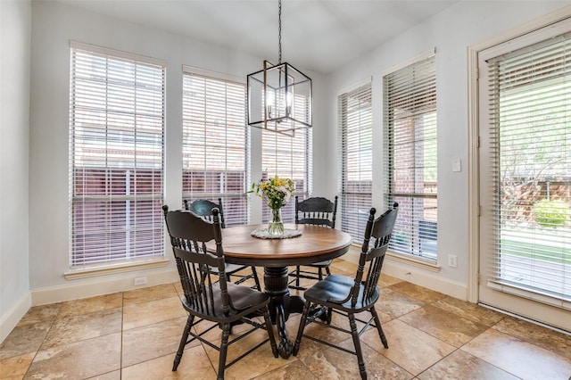 dining space featuring plenty of natural light, baseboards, and an inviting chandelier