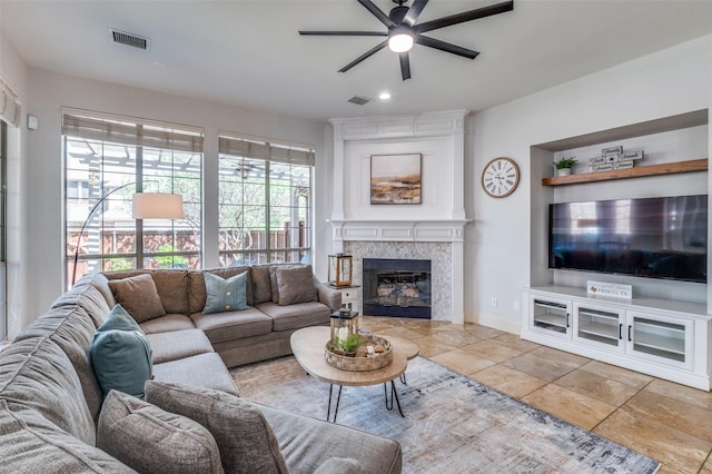 living room with visible vents, baseboards, a ceiling fan, a fireplace, and recessed lighting