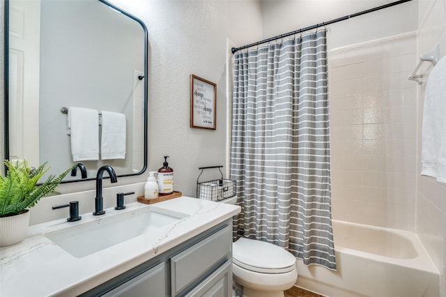 bathroom with shower / bath combo, vanity, toilet, and a textured wall