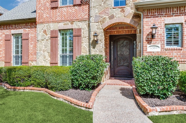 entrance to property featuring brick siding and stone siding
