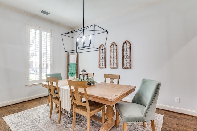 dining area featuring a chandelier, wood finished floors, baseboards, and visible vents