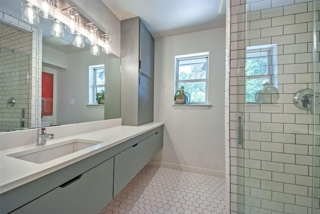 full bathroom with tile patterned flooring, a wealth of natural light, a stall shower, and vanity
