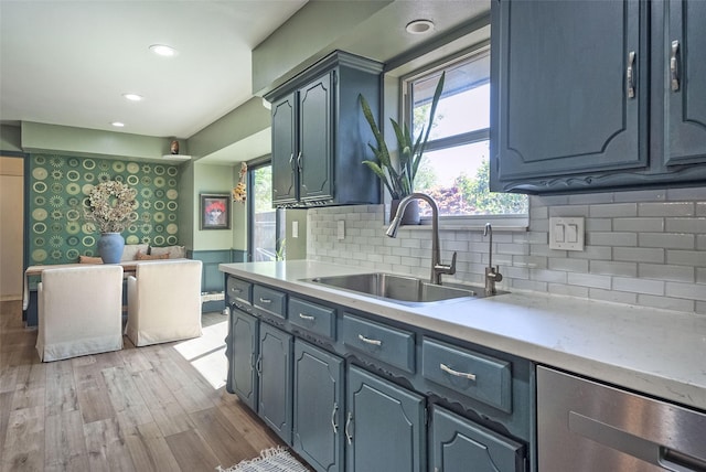 kitchen with a wealth of natural light, light wood-style floors, light countertops, and a sink