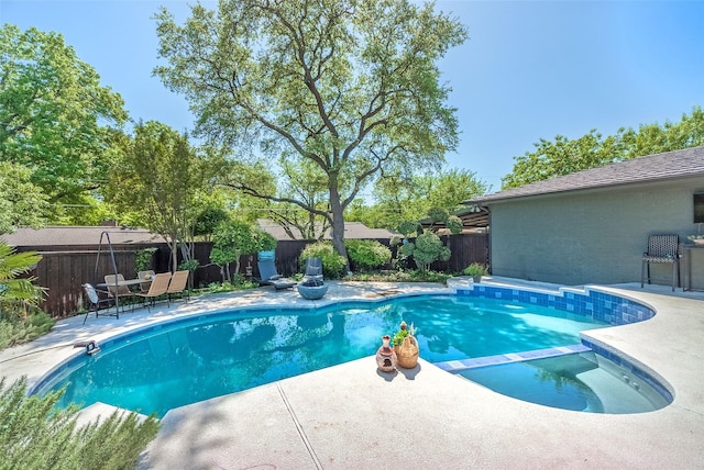 view of pool featuring a patio, a pool with connected hot tub, and a fenced backyard