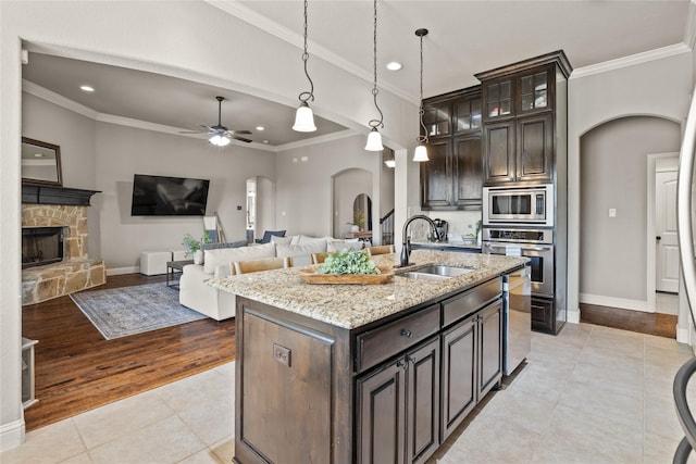 123 Claremont Dr, Ovilla, TX 75154 - kitchen with stainless steel appliances, arched walkways, a sink, light tile patterned floors, and recessed lighting