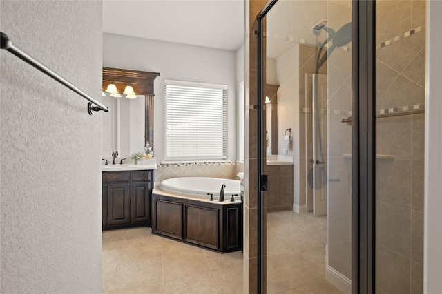 123 Claremont Dr, Ovilla, TX 75154 - full bathroom featuring a stall shower, a garden tub, vanity, tile patterned flooring, and a textured wall
