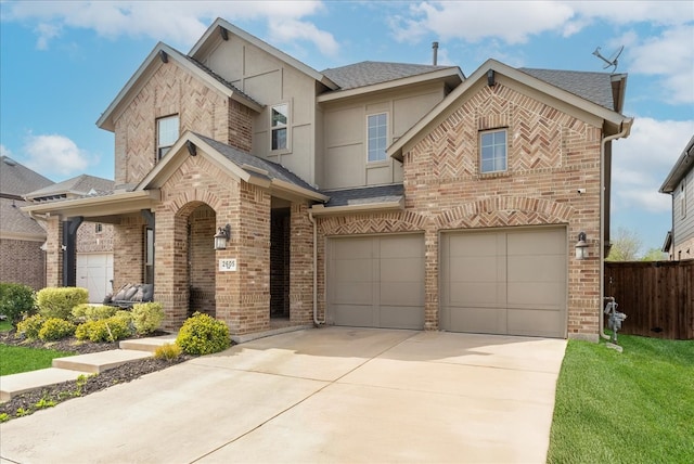 2605 High Bluff Dr, Mansfield, TX 76063 - view of front of home with stucco siding, an attached garage, driveway, and brick siding