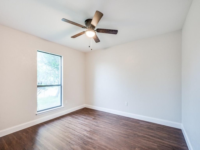 empty room featuring dark wood-type flooring, baseboards, and ceiling fan