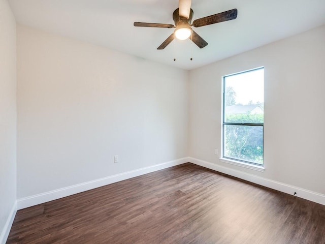 spare room featuring dark wood-style flooring, baseboards, and ceiling fan