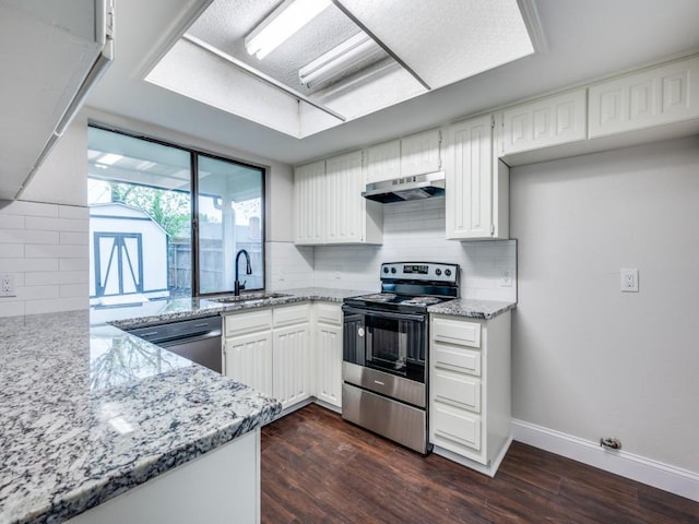 kitchen featuring light stone countertops, black dishwasher, under cabinet range hood, a sink, and electric stove