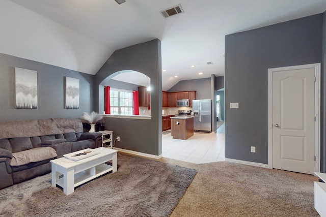 living room featuring visible vents, baseboards, light colored carpet, and vaulted ceiling