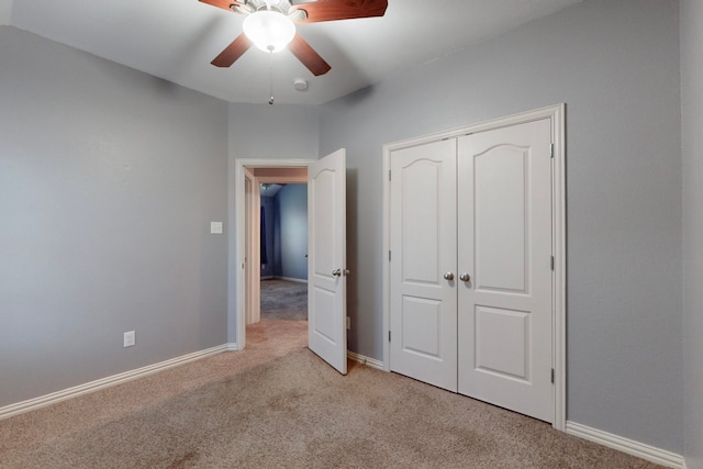 unfurnished bedroom with a closet, baseboards, a ceiling fan, and carpet flooring
