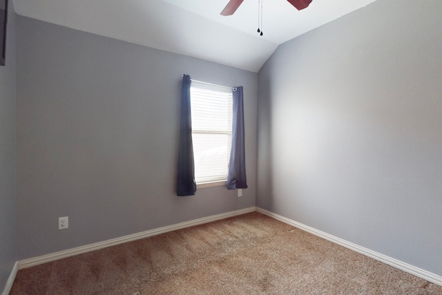 empty room with carpet flooring, lofted ceiling, baseboards, and ceiling fan
