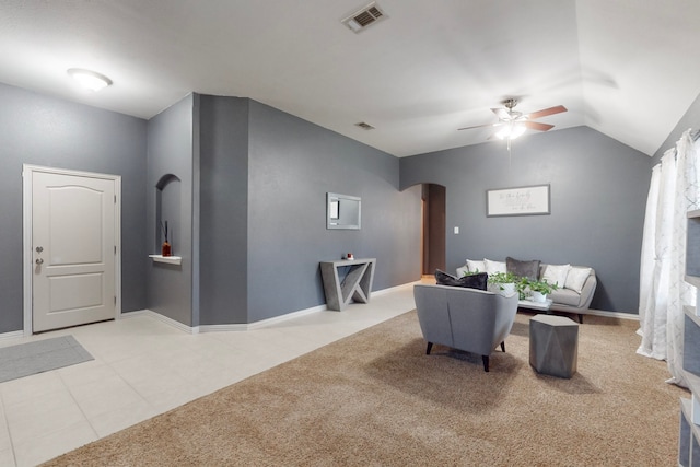 living area with arched walkways, visible vents, light colored carpet, and ceiling fan