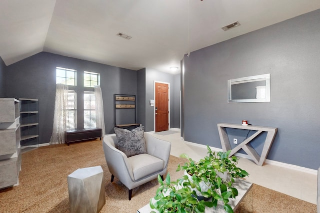 living room with visible vents, baseboards, light colored carpet, and vaulted ceiling