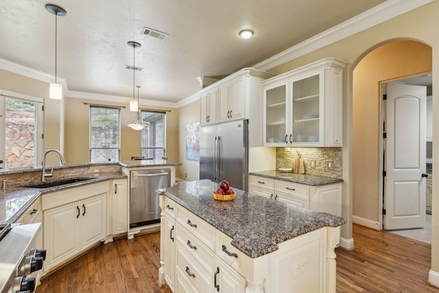 3007 Sunray Valley Ct, Arlington, TX 76012 - kitchen with appliances with stainless steel finishes, a sink, wood finished floors, glass insert cabinets, and crown molding