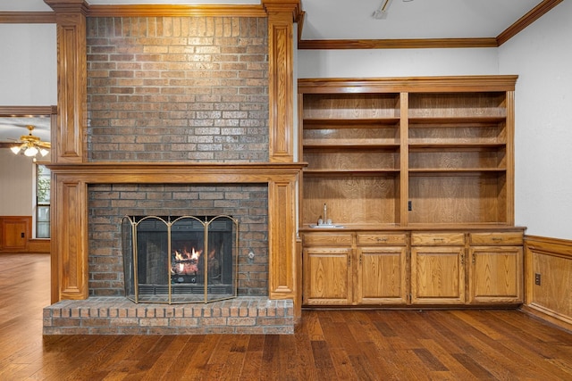 4924 Wolf Creek Trl, Flower Mound, TX 75028 - unfurnished living room featuring dark wood-style flooring, ornamental molding, a wainscoted wall, and a fireplace