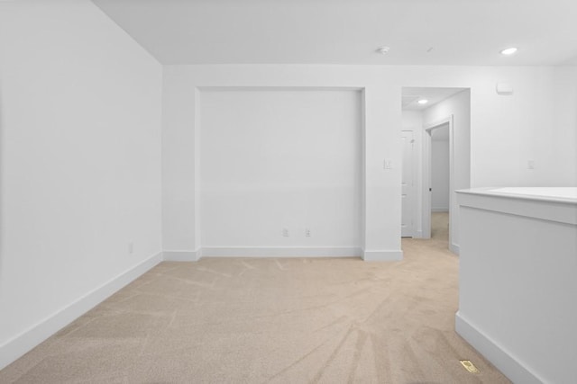 spare room featuring recessed lighting, baseboards, and light carpet