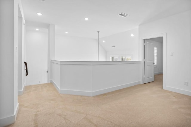 carpeted empty room with baseboards, visible vents, vaulted ceiling, and recessed lighting