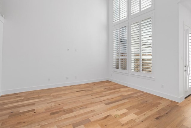empty room with baseboards and light wood-style floors