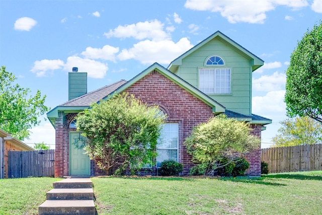 view of front of house featuring brick siding, a front yard, fence, and a chimney