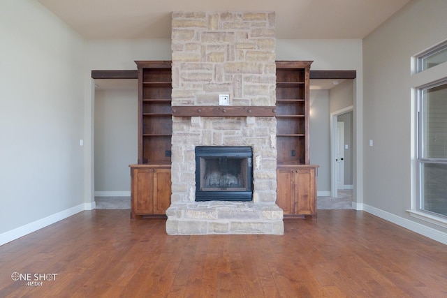 125 Mountain Meadow Dr, Tuscola, TX 79562 - unfurnished living room featuring a stone fireplace, wood finished floors, and baseboards
