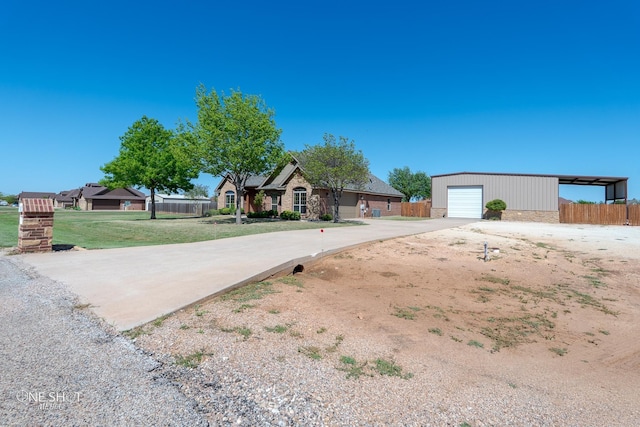 125 Mountain Meadow Dr, Tuscola, TX 79562 - view of front of house featuring a front yard, a detached garage, an outdoor structure, fence, and concrete driveway