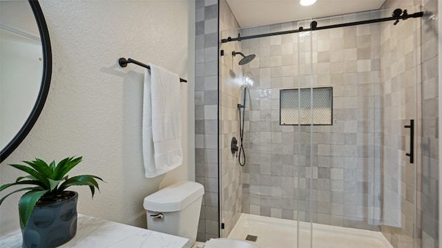 full bathroom with vanity, a textured wall, toilet, and a shower stall