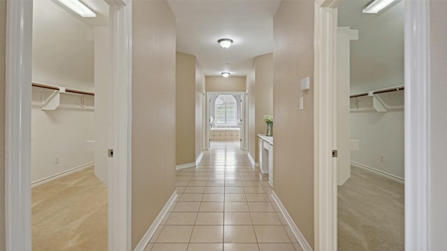 hallway featuring light tile patterned floors and baseboards