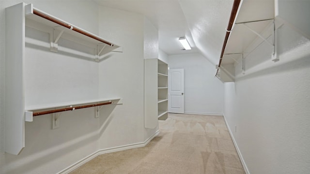 spacious closet with carpet flooring and vaulted ceiling
