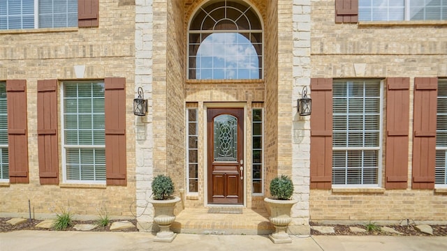 view of exterior entry with brick siding