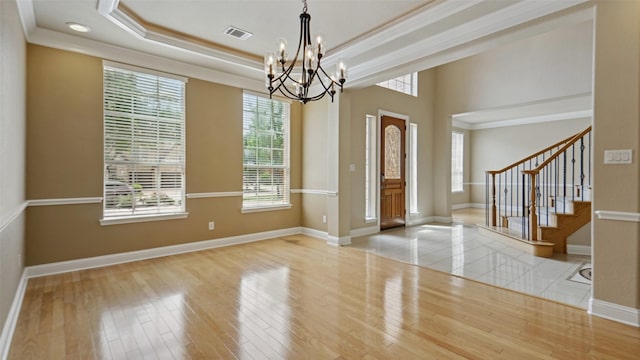 foyer entrance with visible vents, a chandelier, and a wealth of natural light