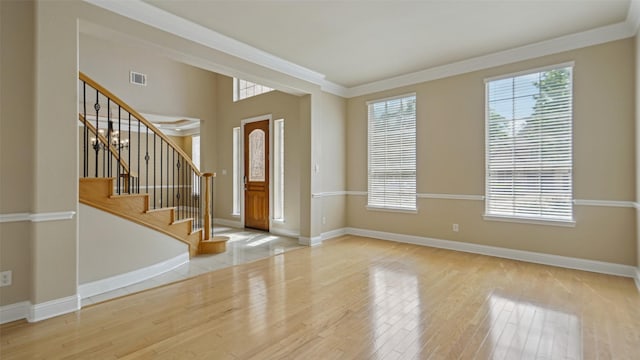 foyer with baseboards, visible vents, and wood finished floors