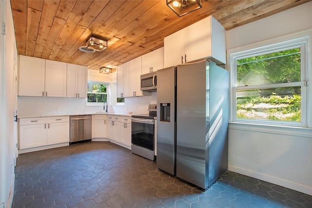 626 N Hampton Rd, Dallas, TX 75208 - kitchen featuring white cabinetry, wood ceiling, a sink, stainless steel appliances, and baseboards