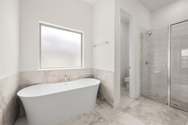 424 Lamb Ln, Waxahachie, TX 75167 - bathroom featuring toilet, a stall shower, marble finish floor, a freestanding bath, and wainscoting