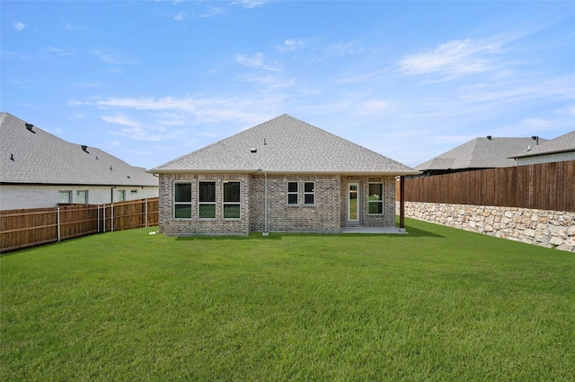 424 Lamb Ln, Waxahachie, TX 75167 - back of property with brick siding, roof with shingles, a fenced backyard, and a lawn