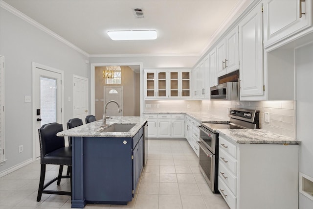 8508 Landing Way Ct, Fort Worth, TX 76179 - kitchen with stainless steel appliances, a sink, decorative backsplash, white cabinetry, and light tile patterned flooring