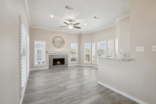 8508 Landing Way Ct, Fort Worth, TX 76179 - unfurnished living room with plenty of natural light, ceiling fan, a tile fireplace, ornamental molding, and baseboards