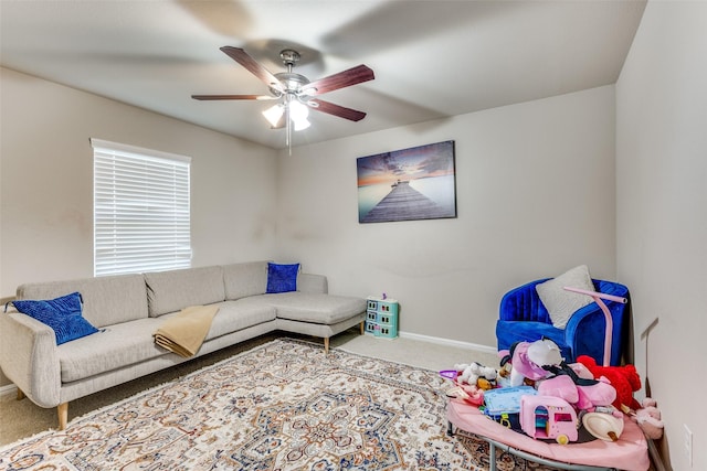 living room with carpet flooring, baseboards, and a ceiling fan